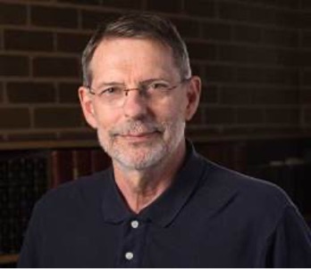 Noel Cressie wears a dark polo shirt and glasses. He has short brown hair.